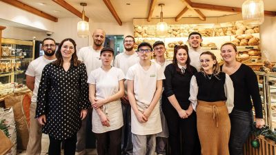 L’équipe de la boulangerie-pâtisserie La Madeleine à Saint-Pierre-Église, réunie dans la boutique autour des artisans boulangers et pâtissiers.