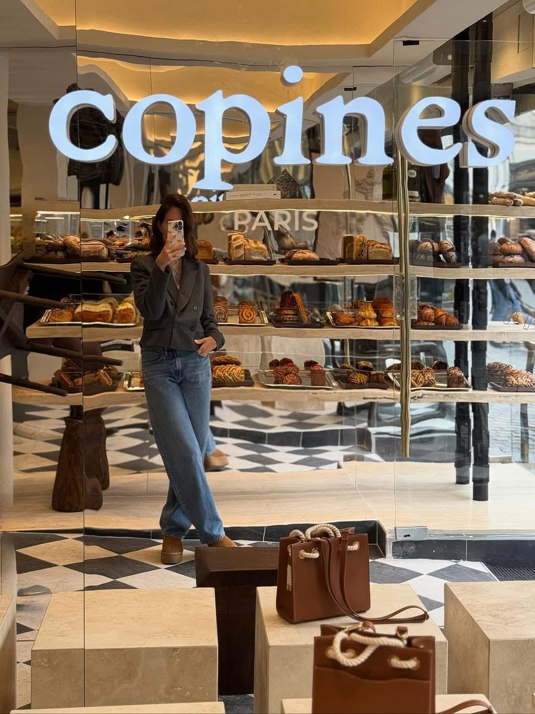 Devanture de la boulangerie Copines Paris à Bruxelles, avec une cliente prenant une photo devant les vitrines remplies de viennoiseries artisanales