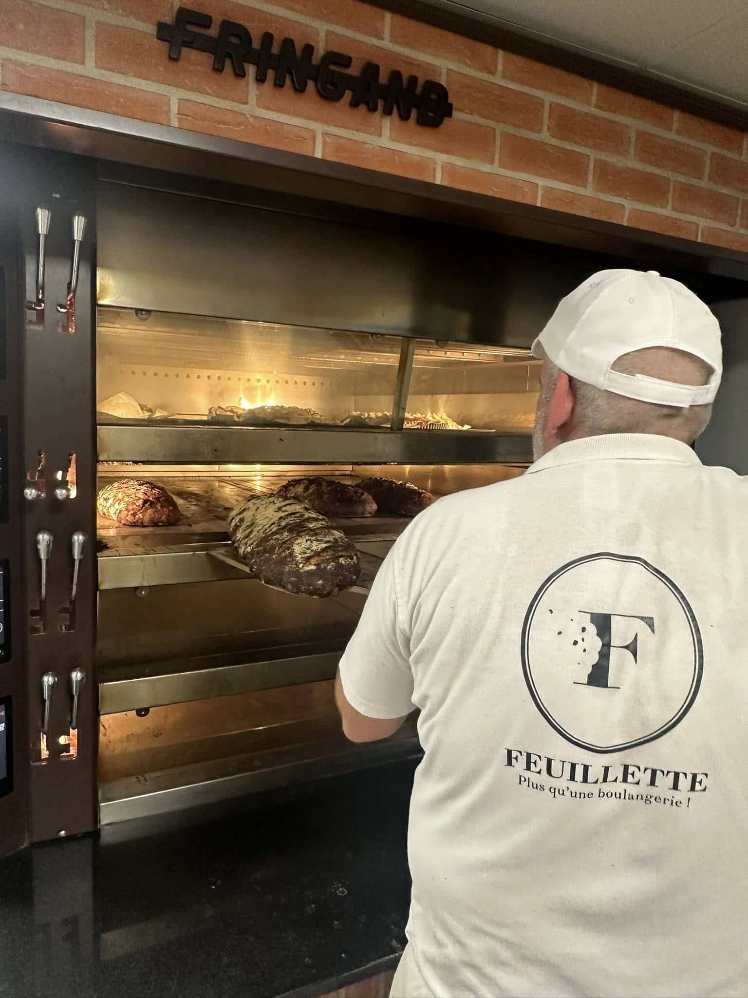 Boulanger Feuillette à Sausheim enfournant des pains artisanaux dans le four Fringand, symbole du savoir-faire de l’enseigne
